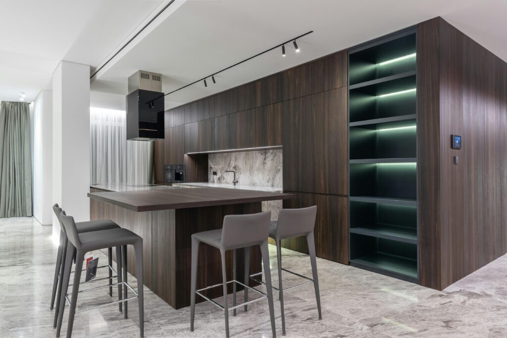Modern interior design of contemporary spacious kitchen with dining zone and wooden furniture in apartment