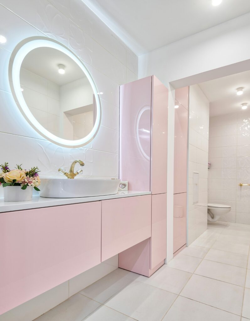 Stylish modern bathroom featuring pink cabinetry and elegant decoration, perfect for home luxury inspiration.